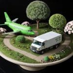 Miniatuurlandschap met vliegtuig, vrachtwagen en bomen als symbool voor duurzame logistiek