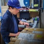 Medewerker sorteert pakketten in het magazijn van MT Unirepair